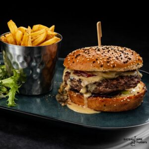 Burger gourmand steak 180g (France) munster, saucisse fumée, pomme de terre rôties, poireaux, crème et confit d’oignons